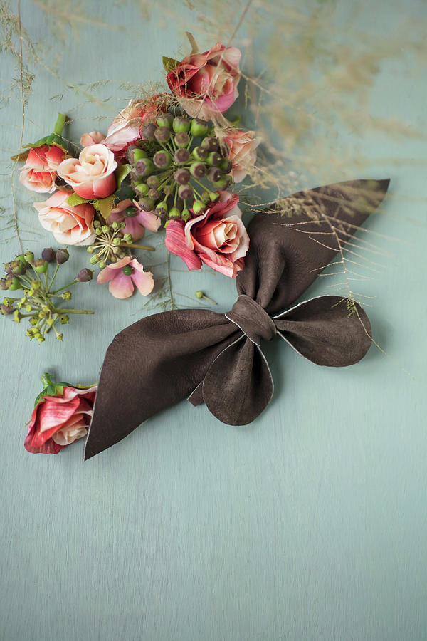 Leather Bow, Fabric Flowers And Ivy Berries On Grey Surface Photograph by Alicja Koll