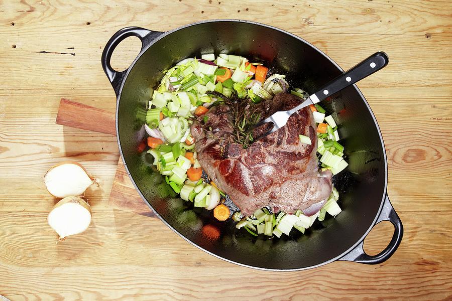 Leg Of Venison With Rosemary, Onions, Leeks And Carrots In A Braising Dish Photograph by Bjrn Llf