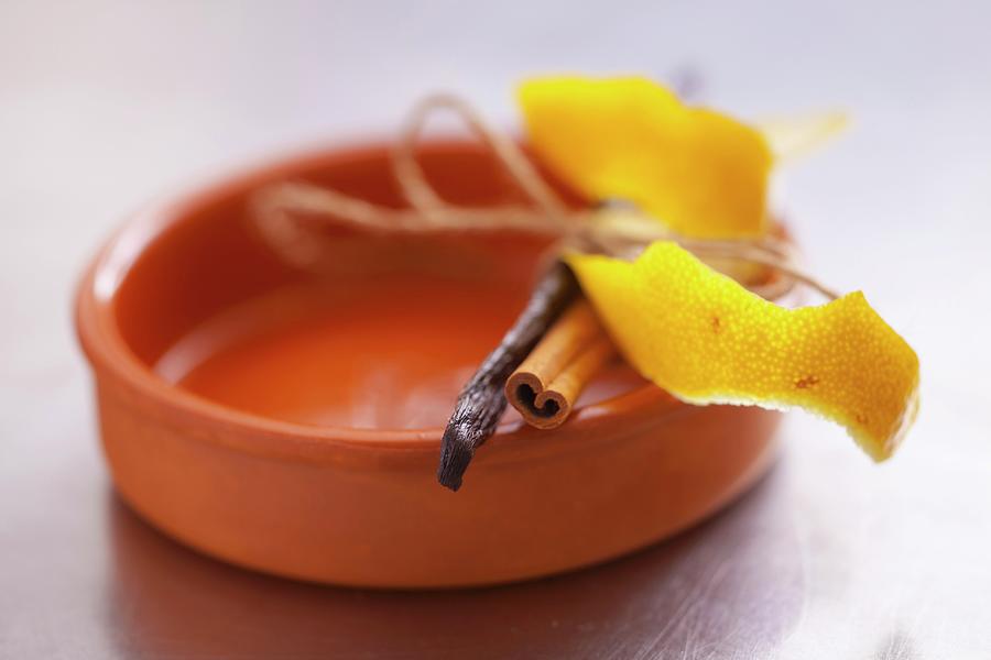 Lemon Peel, A Cinnamon Stick And A Vanilla Pod On A Ramekin Photograph by Studio Lipov