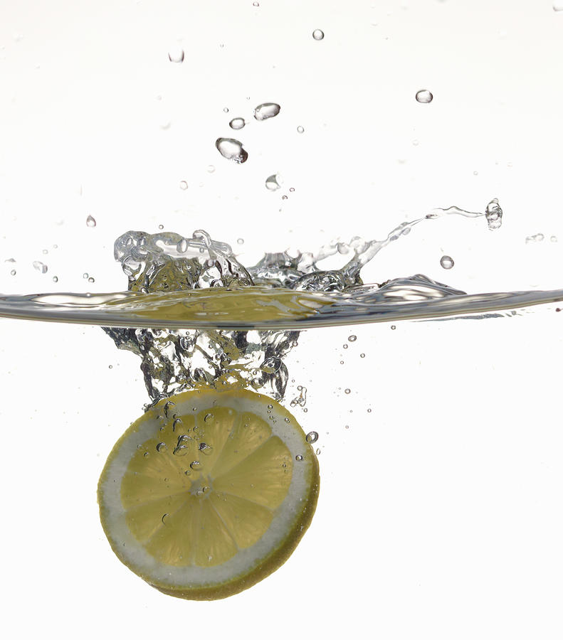 Lemon Slice In Fresh Water Photograph by Buena Vista Images