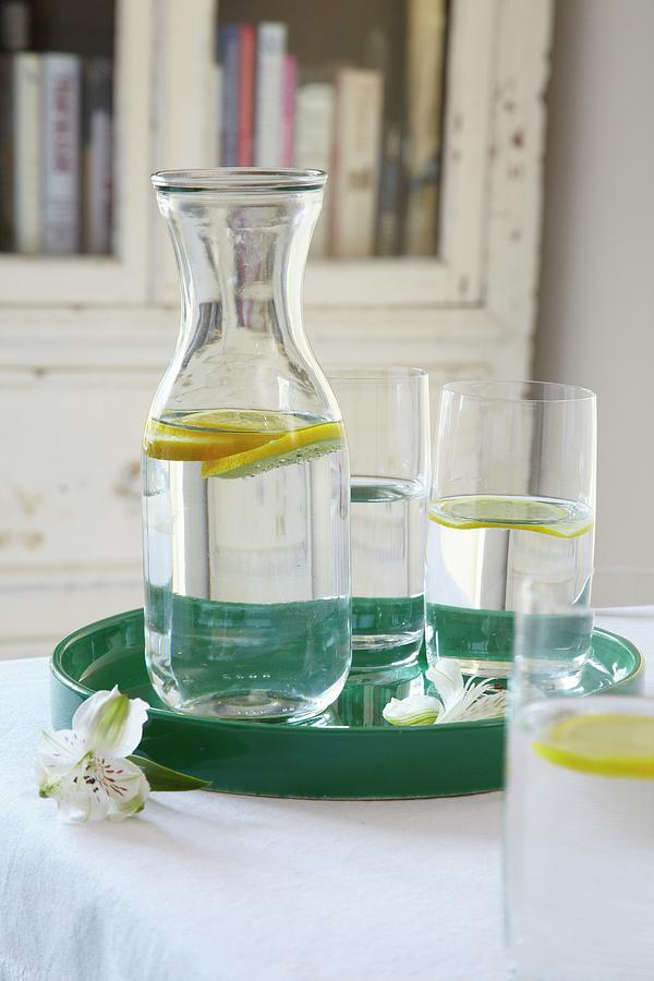 Lemon Water In A Carafe And In Glasses On A Tray Photograph by Simon ...