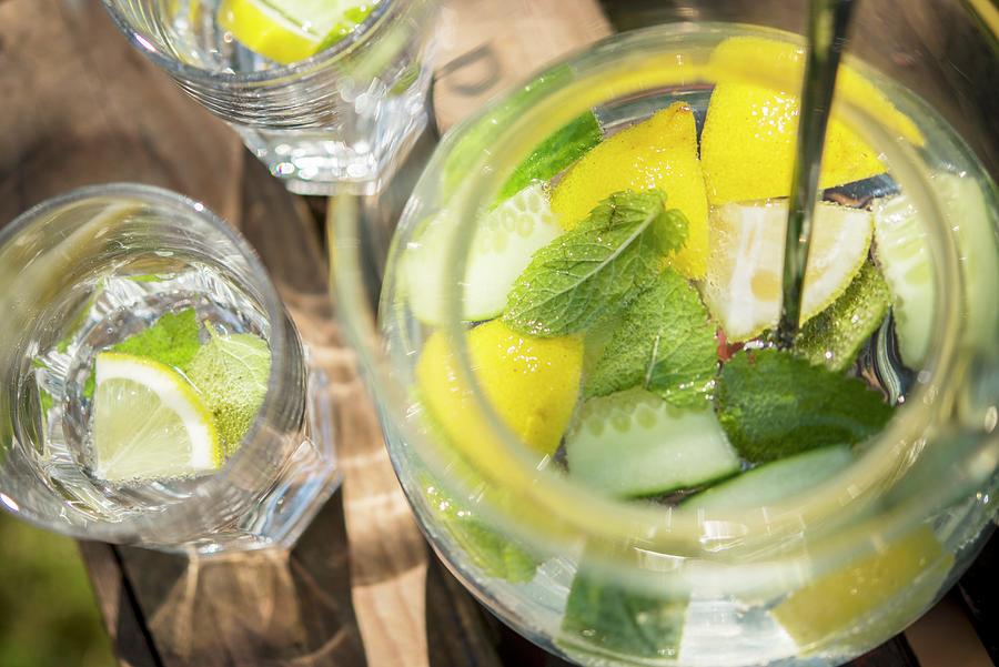 Lemon Water With Cucumber And Mint On A Wooden Crate In The Garden Photograph by Sebastian Schollmeyer