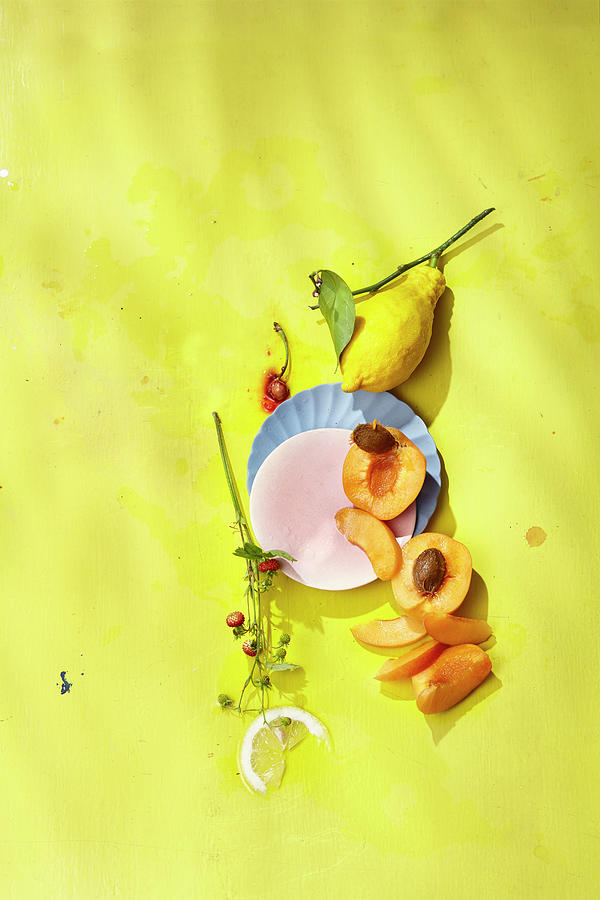 Lemons And Apricots On A Yellow Background Photograph by Ulrike Stockfood Studios / Holsten