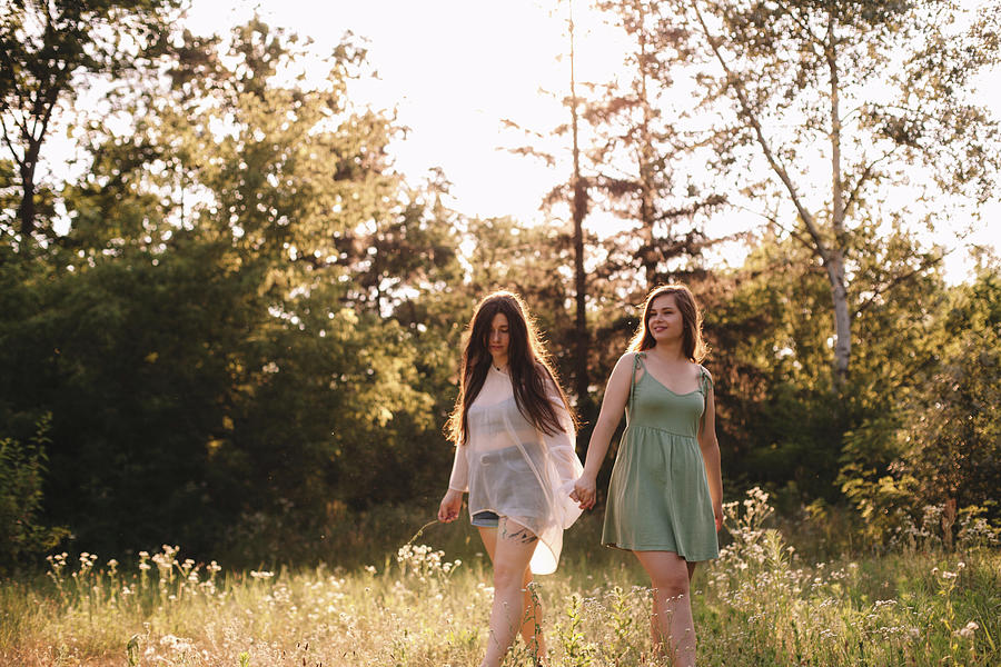 Lesbian Couple Holding Hands While Standing In Forest In Summer Photograph By Cavan Images