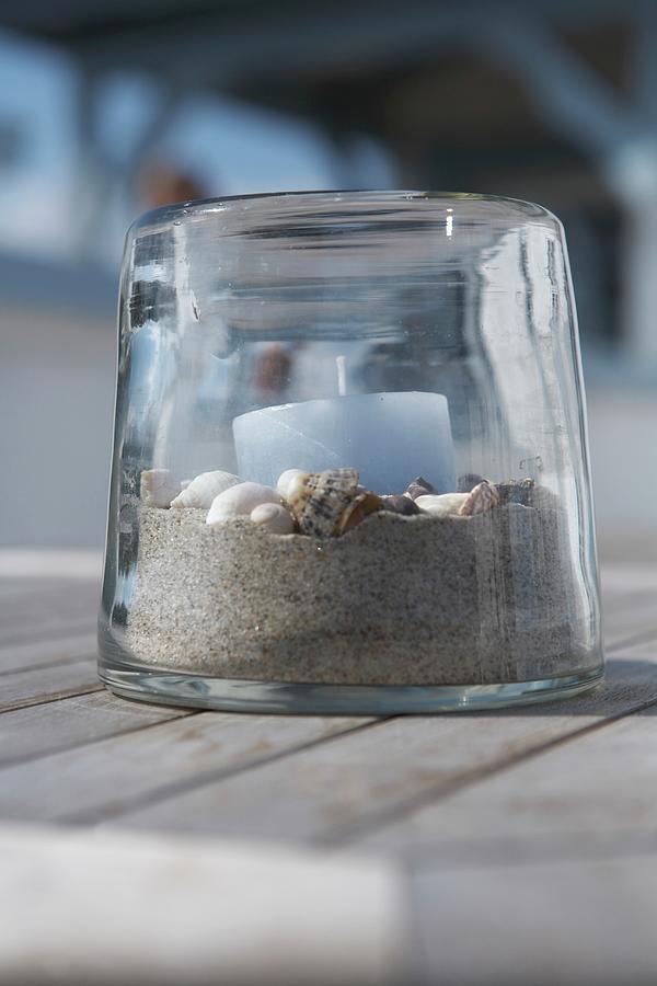 Light Blue Candle On Bed Of Sand And Shells In Transparent Candle Lantern Photograph by Greenhaus Press