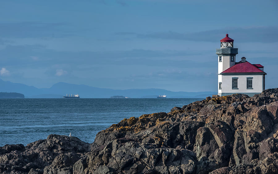 Lighthouse And Distant Ships Photograph by Russell Illig