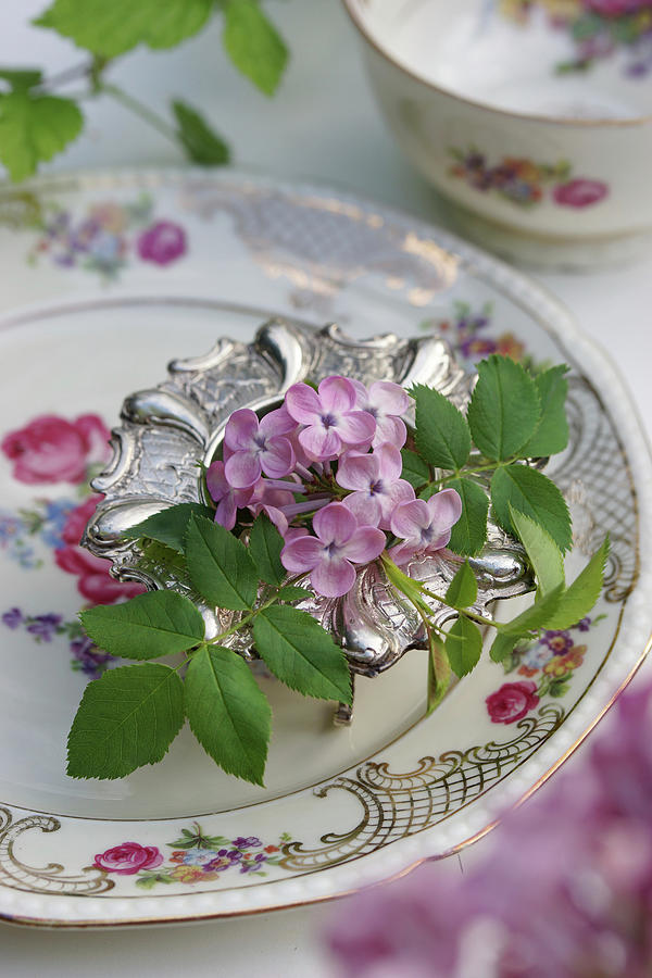 Lilac Blossoms And Rose Petals In A Silver Egg Cup Photograph by Angelica Linnhoff