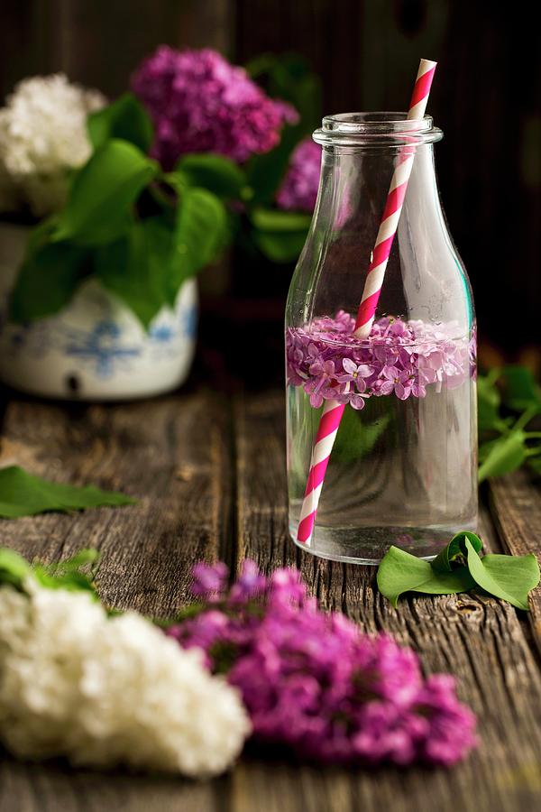 Lilac Flower Water In A Bottle With A Straw Photograph by Sandra Krimshandl-tauscher