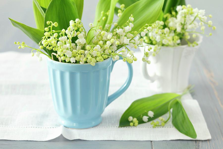 Lily Of The Valley In Ceramic Mugs On Linen Cloth Photograph by Rua Castilho