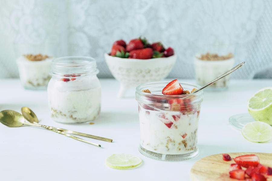 Lime And Strawberry Posset With Streusel In Glass Jars On A White Background Photograph by Albina Bougartchev