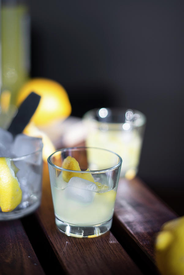 Limoncello With Ice Cubes And Fresh Lemon Peel Photograph by Myriam Meliani