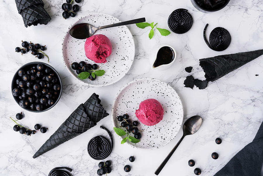 Liquorice Ice Cream With Blackcurrants On White Dessert Plates Photograph by Christian Kutschka