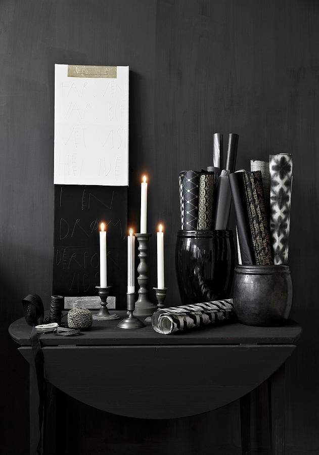 Lit Candles And Rolls Of Paper In Containers On Black Console Table Photograph by Lykke Foged & Morten Holtum