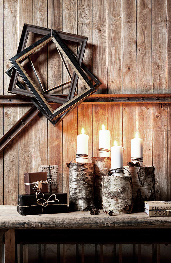Lit Candles On Wooden Bench Below Old Picture Frames On Rustic Board Wall Photograph by Lykke Foged & Morten Holtum