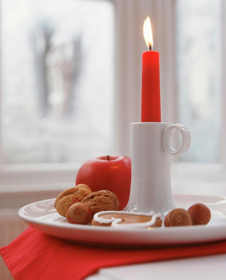 Lit Red Candle In White China Candlestick With Nuts, Apples And Gingerbread Photograph by Veronika Stark