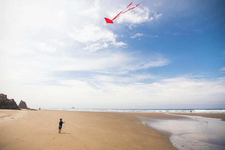 Dragon Photograph - Little Boy Flies A Kite On The Beach by Cavan Images