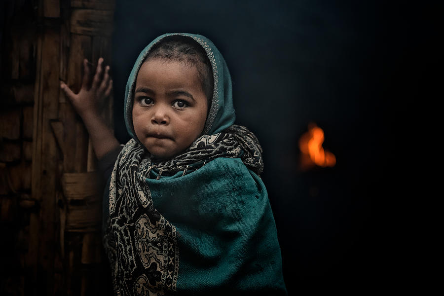 Documentary Photograph - Little-girl-at-the-door---fires-burn-inside-the-house-in-the-dorze-tribe by Veli Aydogdu