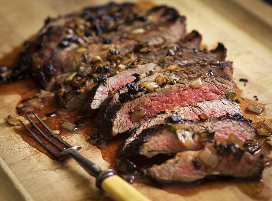 London Broil Steak Sliced On A Cutting Board With Carmelized Onions And A Vintage Carving Fork Photograph by Don Crossland