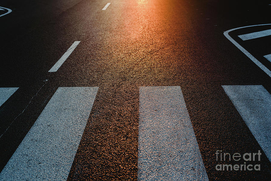 Lonely street with pedestrian crossing at sunset, texture with space for text. Photograph by Joaquin Corbalan