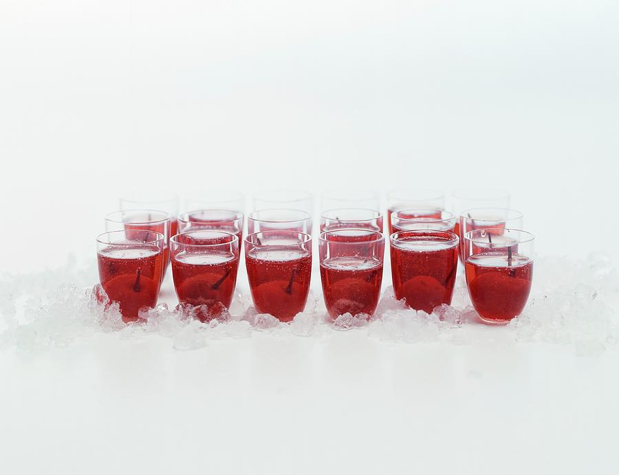 Lots Of Schnapps Glasses On Crushed Ice With Cherry Liqueur And Cherries Photograph by Michael Wissing
