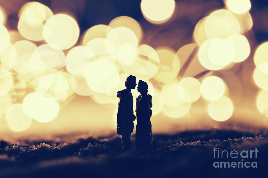 Loving couple standing in a cozy winter scenery. Photograph by Michal Bednarek