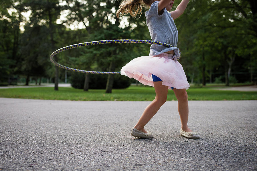 Tree Photograph - Low Angle View Of Girl Playing With Hula Hoop On Footpath by Cavan Images