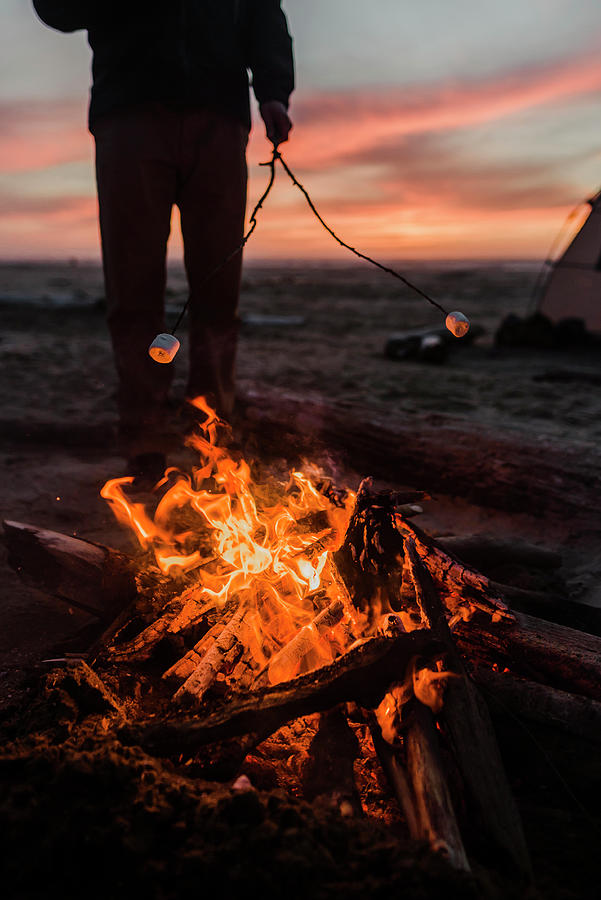 Nature Photograph - Low Section Of Man Roasting Marshmallows Over Campfire At Beach by Cavan Images