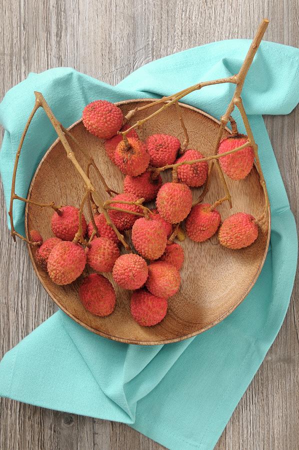 Lychees On Twigs On A Wooden Plate Photograph by Jean-christophe Riou