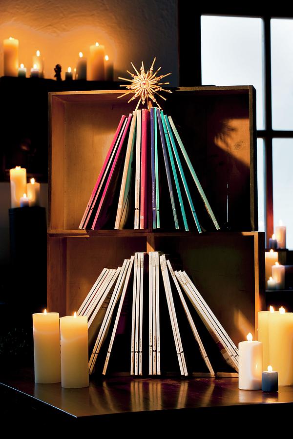 Magazines Arranged In Shape Of Christmas Tree In Wooden Crates With Straw Star And Lit Candles Photograph by Sabine Lscher