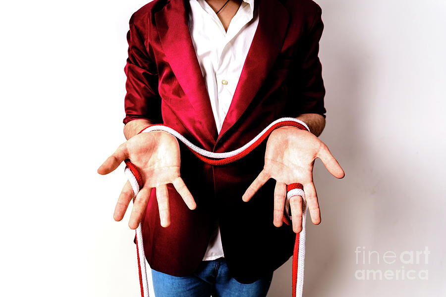Magician hands handling ropes and bandanas to do magic tricks, isolated on white. Photograph by Joaquin Corbalan