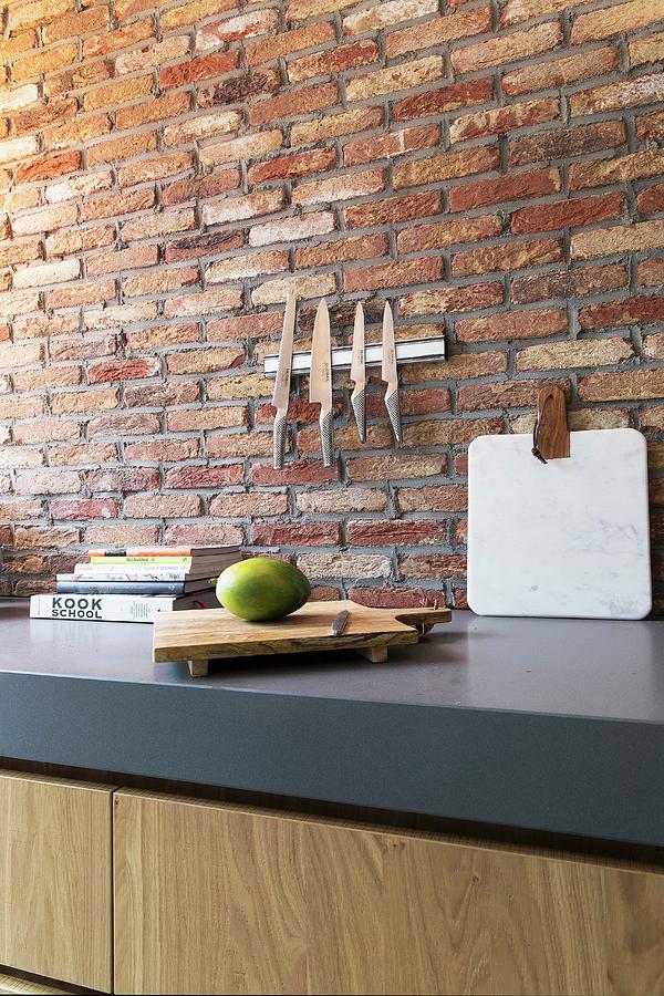 Magnetic Knife Rack On Brick Wall Above Grey Kitchen Worksurface Photograph by Jansje Klazinga