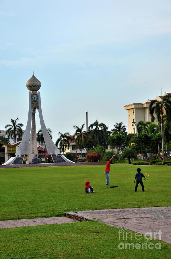 Malay kids play badminton at Dataran gardens with clock tower Ipoh Perak Malaysia Photograph by Imran Ahmed