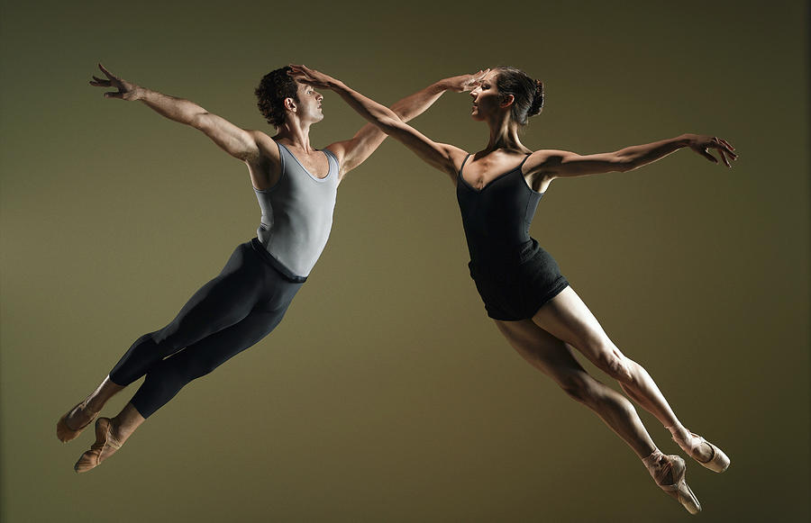 Male And Female Ballet Dancers Leaping by Ryan Mcvay