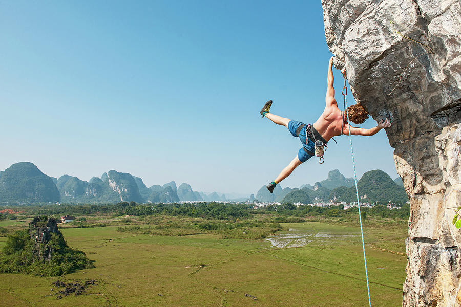 Sports Photograph - Male Climber Hanging Sideways On Overhanging Rock In Yangshuo / China by Cavan Images
