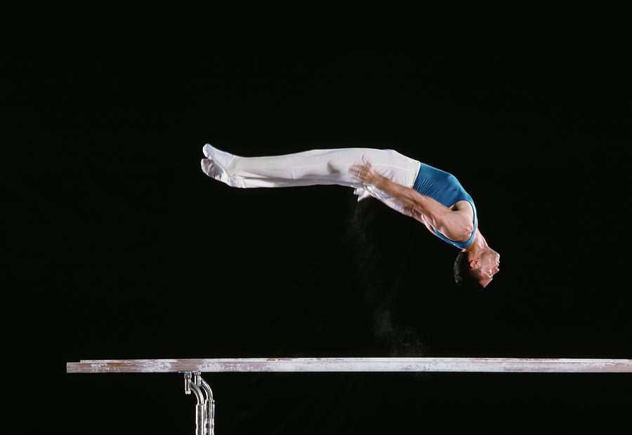 Male Gymnast Performing On Parallel Bars Photograph by David Madison
