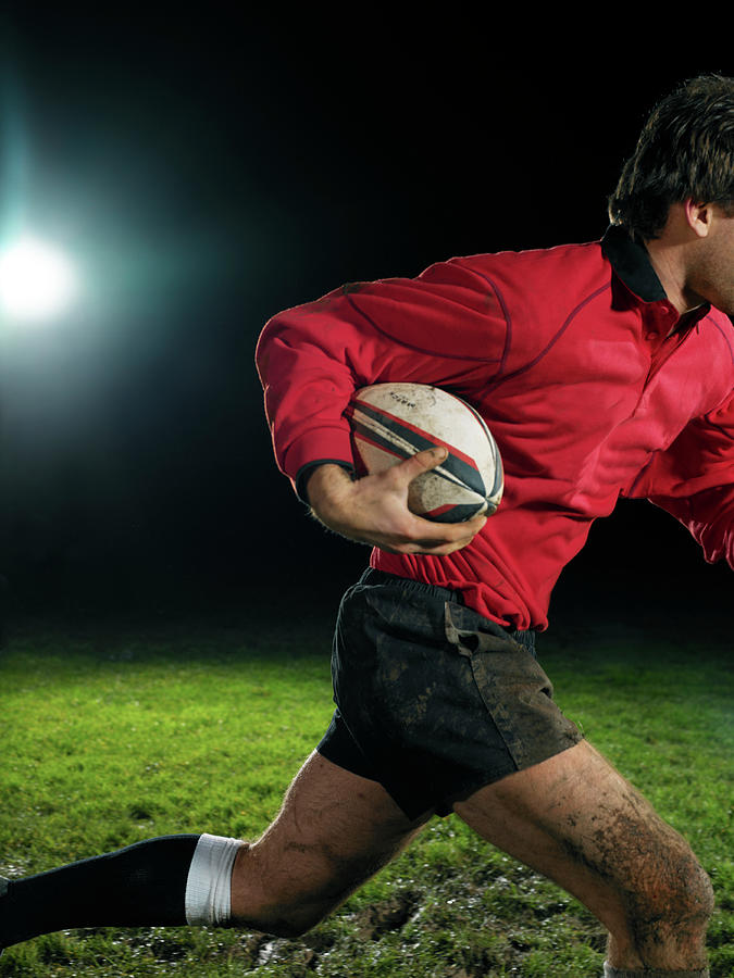Male Rugby Player Holding Ball, Night Photograph by Thomas Barwick