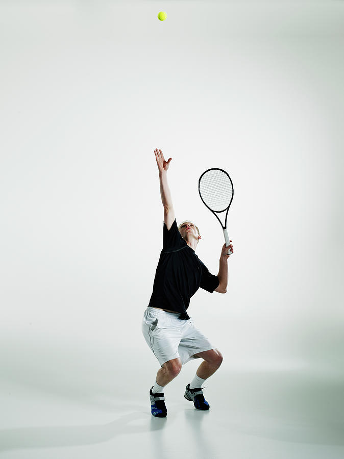 Male Tennis Player Serving Ball Photograph by Thomas Barwick