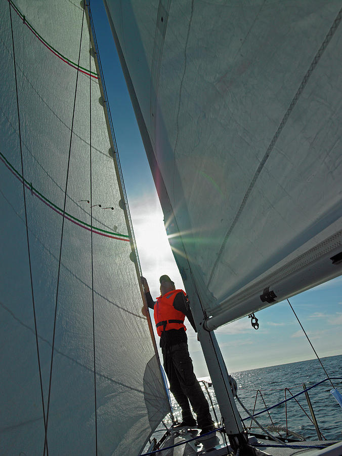 Man Checking On His Spinnaker Sail While Sailing In Iceland Photograph By Cavan Images