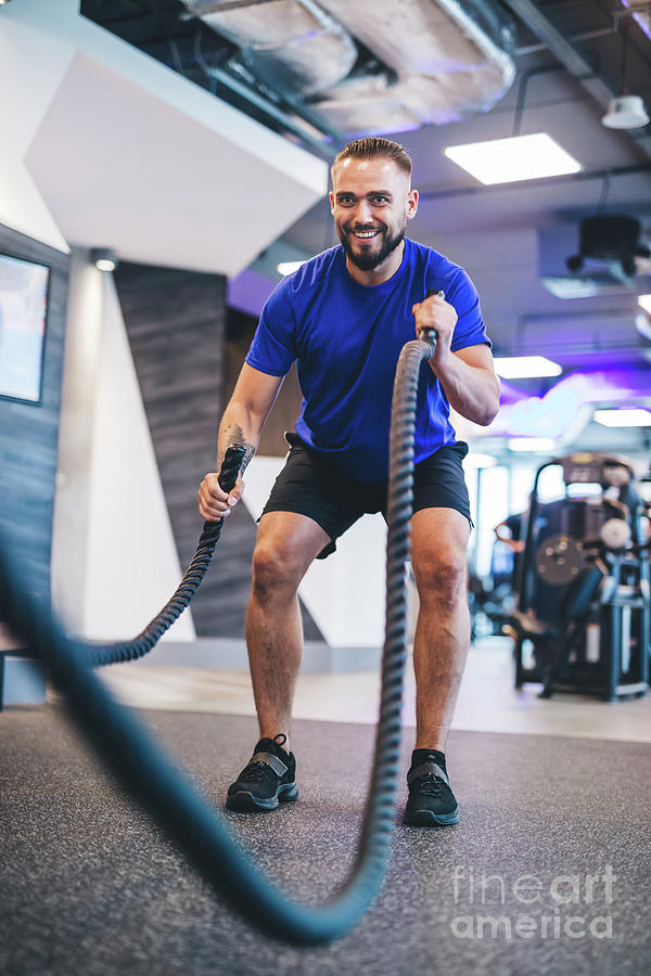 Man exercising with ropes at the gym. Photograph by Michal Bednarek