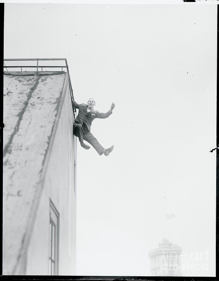 Man Hanging Over A Buildings Edge Photograph by Bettmann