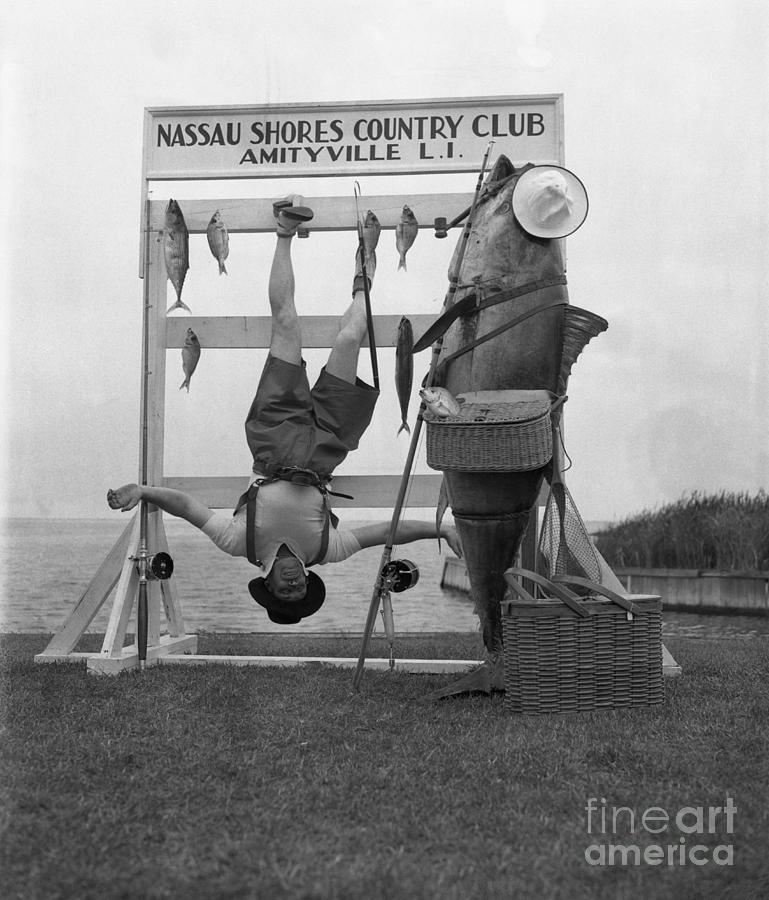 Man Hanging Upside Down With Dead Fish Photograph by Bettmann