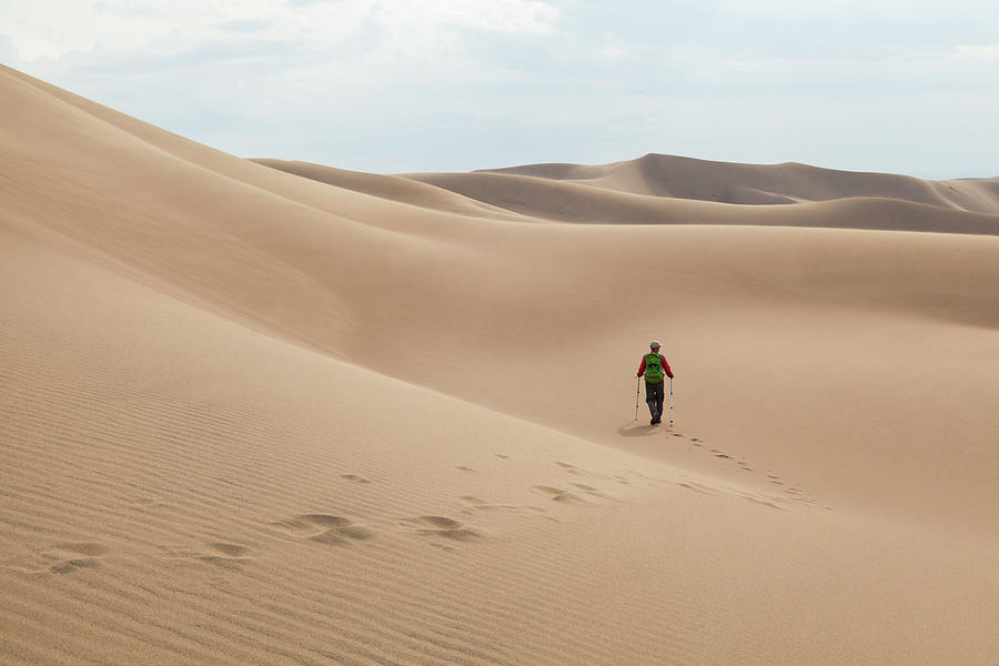 Man Hikes Across A Sand Dune Photograph by Cavan Images | Fine Art America