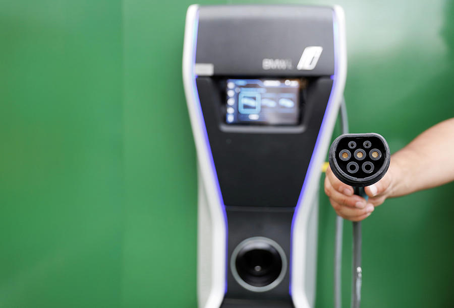 Man Holds an Electric Car Charger Photograph by Nacho Doce - Fine Art ...