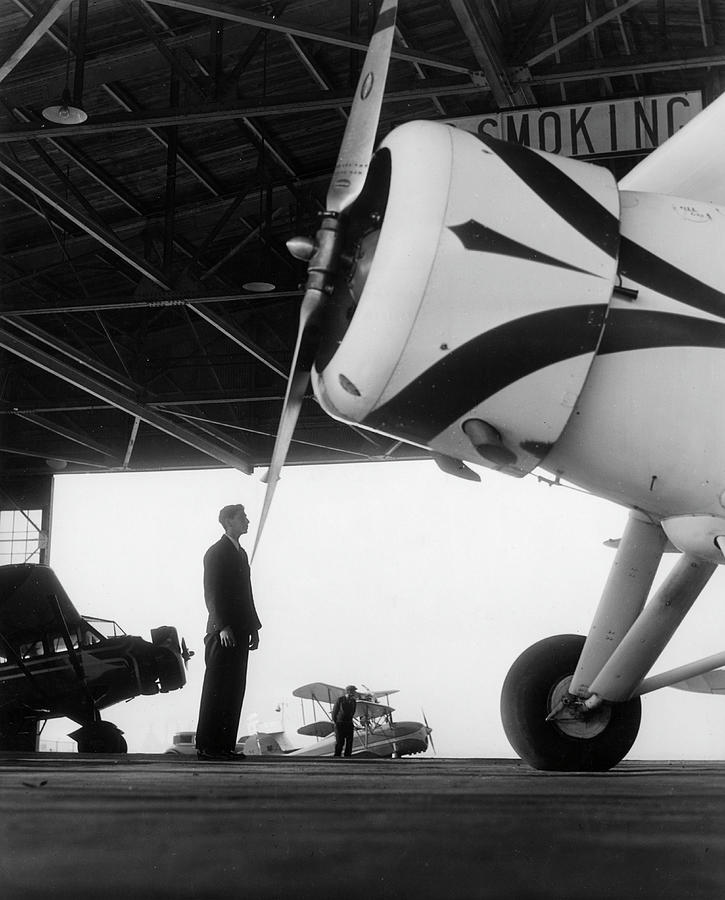 Man In Hangar Looking At Plane Photograph by The New York Historical Society