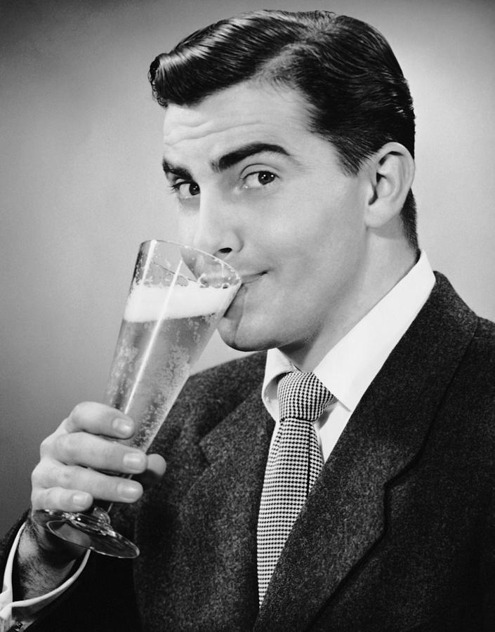Man In Suit Drinking Tall Glass Of Beer Photograph by George Marks