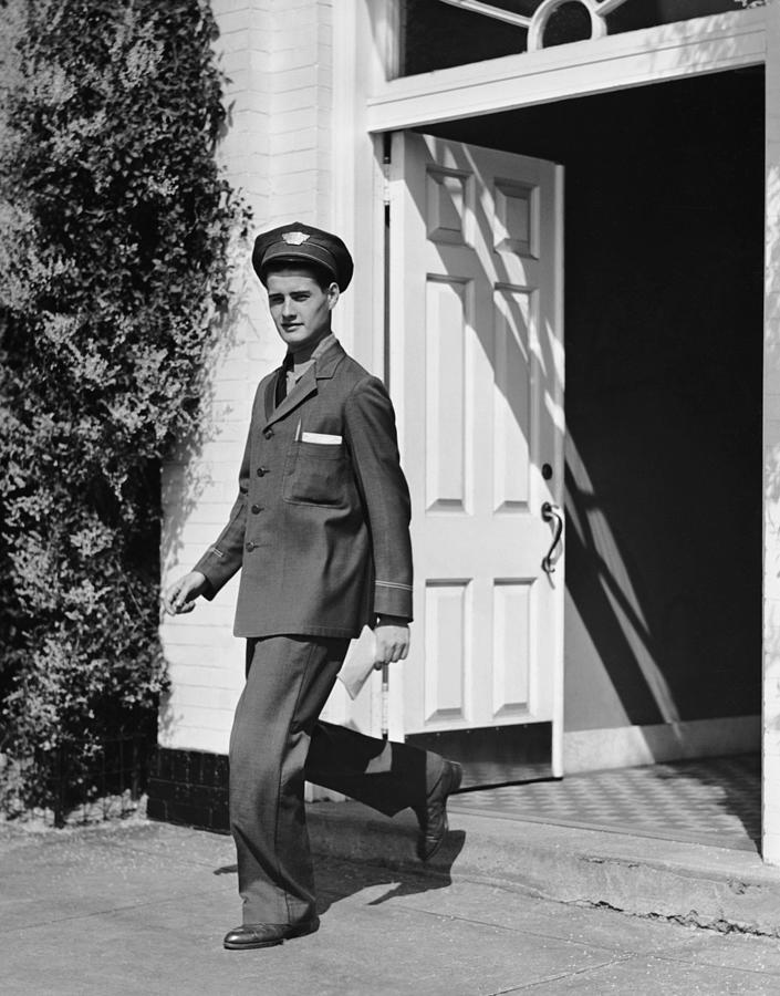 Man In Uniform Walking Out Door Photograph by George Marks