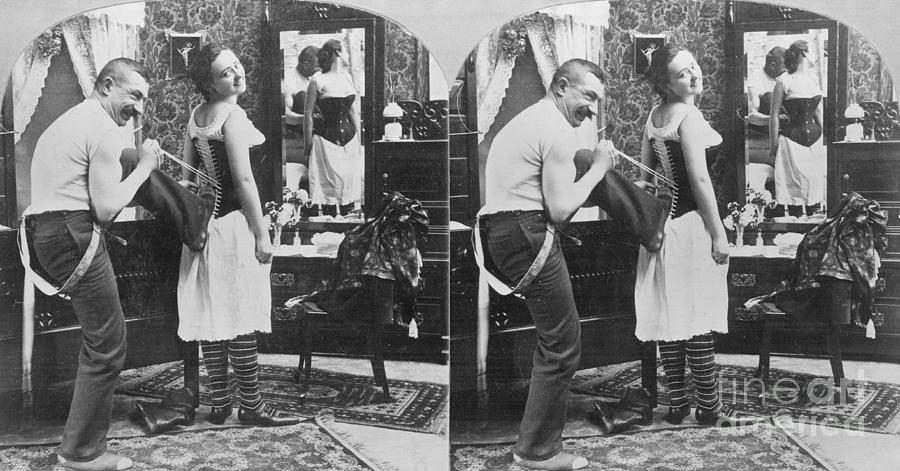 Man Lacing Womans Corset Photograph by Bettmann