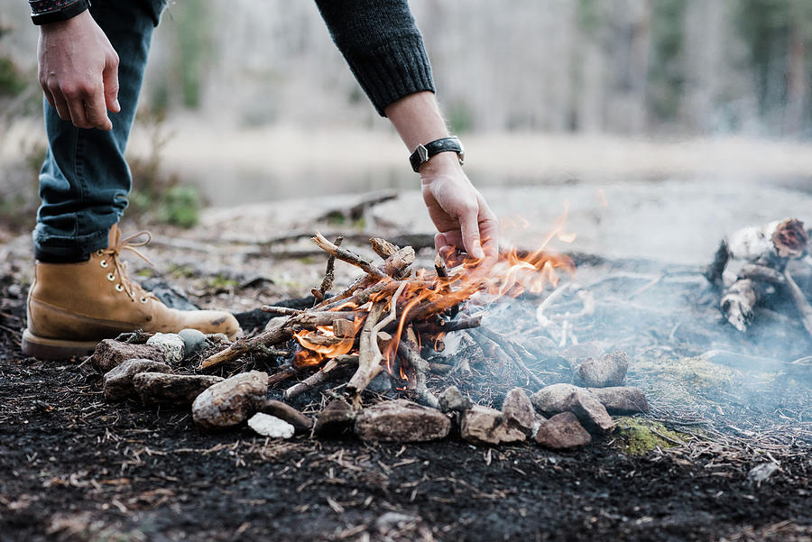 Man Putting Logs On A Handmade Campfire Outdoors In Sweden Photograph ...