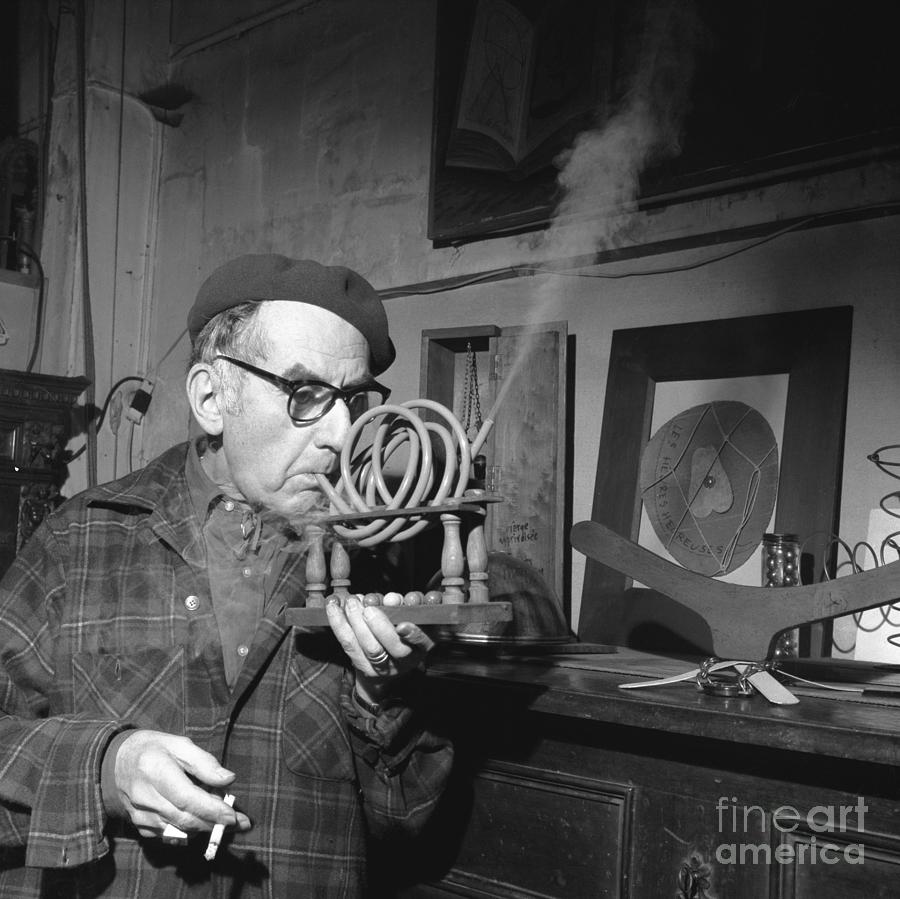 Man Ray Demonstrating His Piece Smoking Photograph by Bettmann