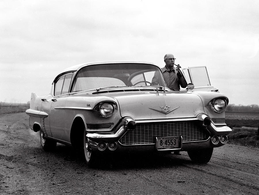 Man smoking pipe by 1958 Cadillac Photograph by Marilyn Hunt